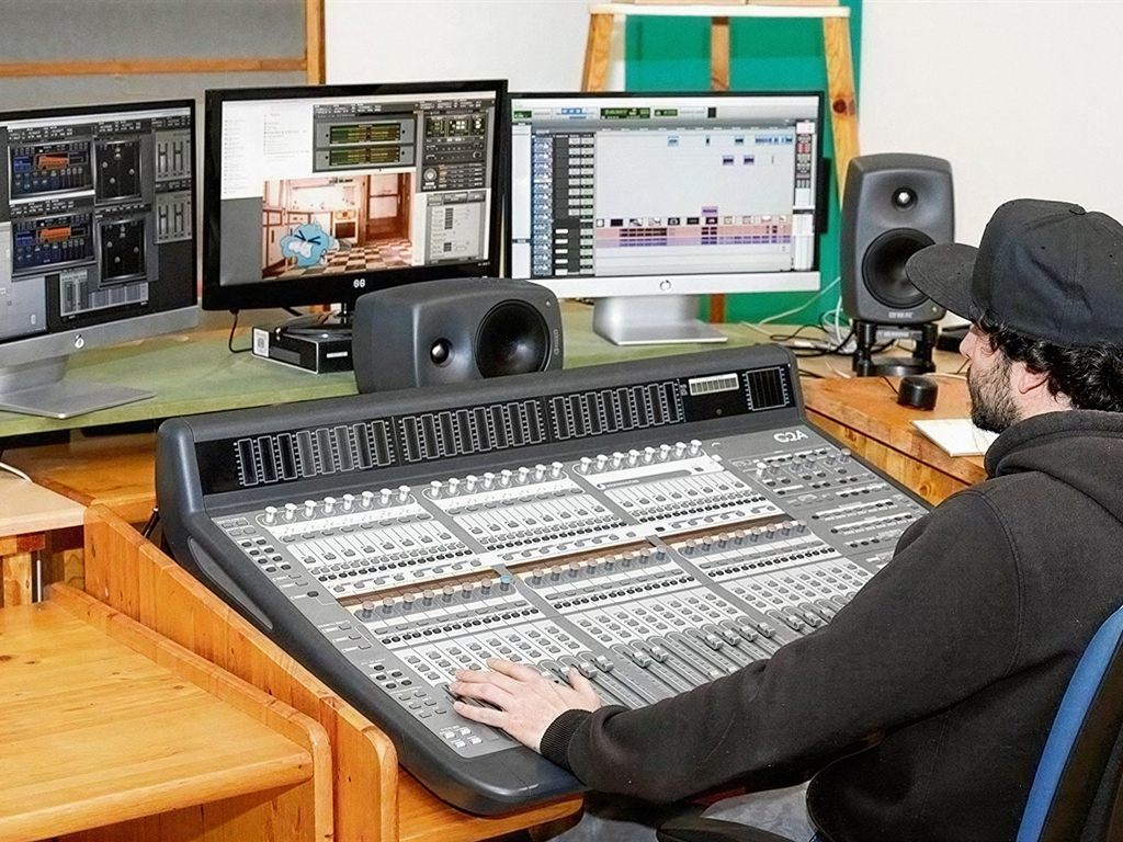 Técnico en la mesa de mezclas durante la postproducción audiovisual en el estudio de doblaje en Vigo